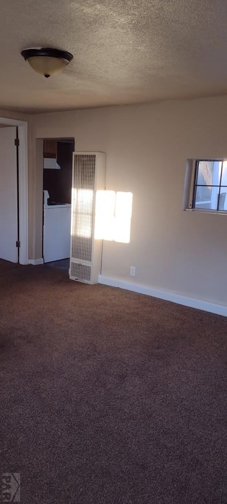 carpeted spare room with a textured ceiling and baseboards