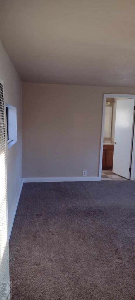 carpeted spare room with baseboards