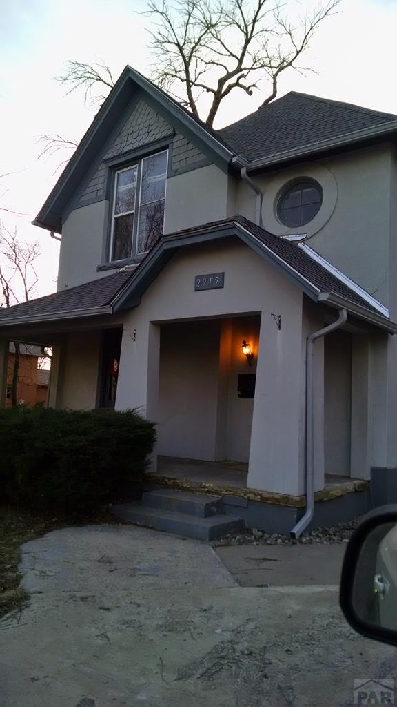 exterior space featuring a shingled roof and stucco siding