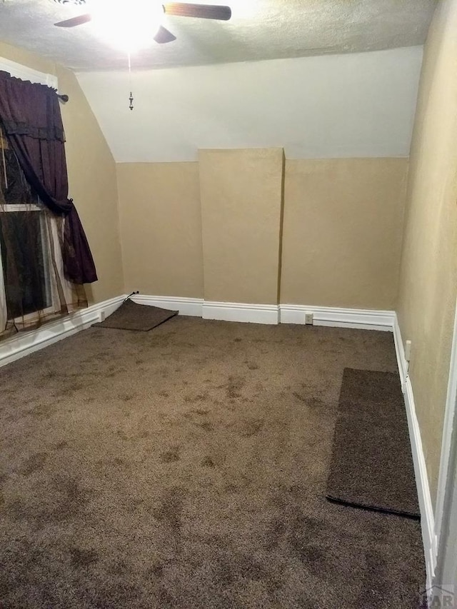 additional living space with vaulted ceiling, carpet, a ceiling fan, and baseboards