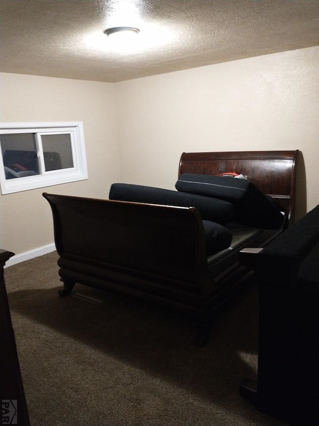 carpeted office space with a textured ceiling and baseboards