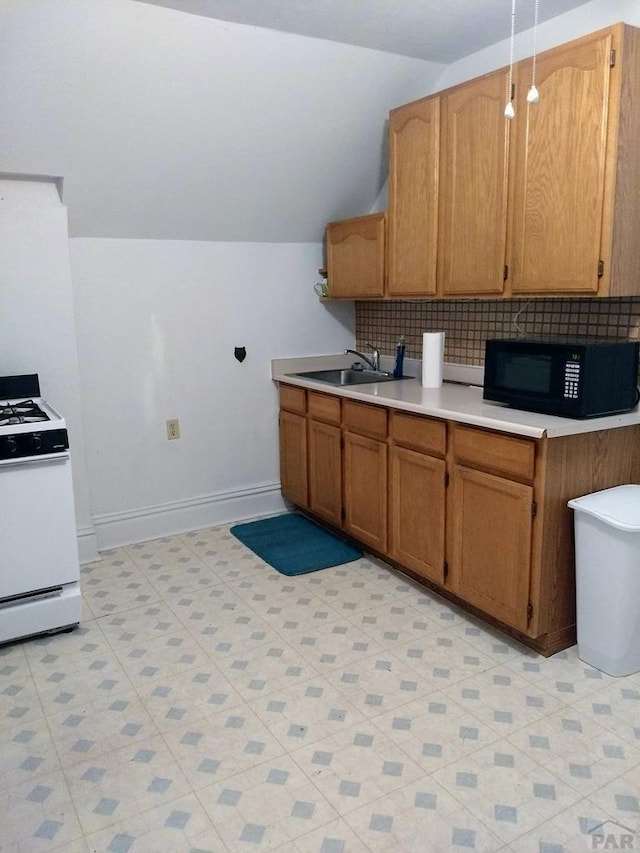 kitchen featuring brown cabinets, white gas stove, light countertops, a sink, and black microwave