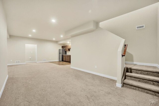 unfurnished living room featuring recessed lighting, visible vents, baseboards, and stairs