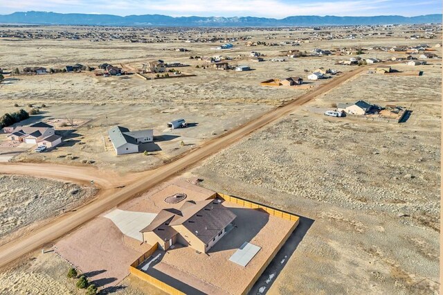 birds eye view of property featuring view of desert and a mountain view