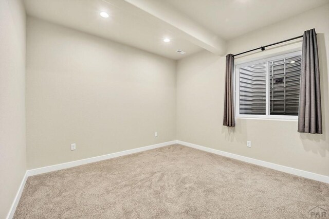 spare room with recessed lighting, beamed ceiling, carpet, and baseboards