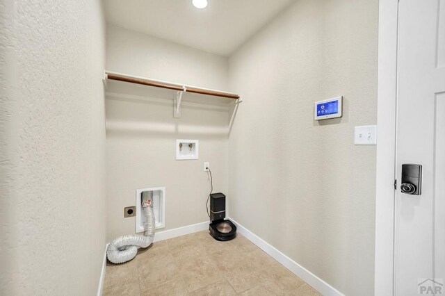 clothes washing area with baseboards, laundry area, hookup for a washing machine, and hookup for an electric dryer