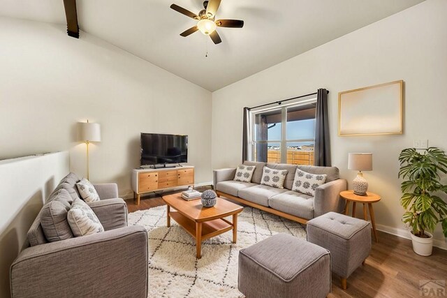 living area featuring light wood-style flooring, ceiling fan, and lofted ceiling with beams