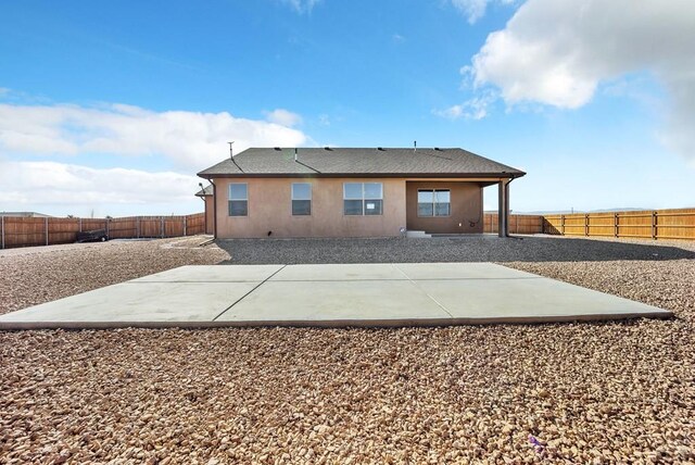 rear view of house with a patio area, a fenced backyard, and stucco siding