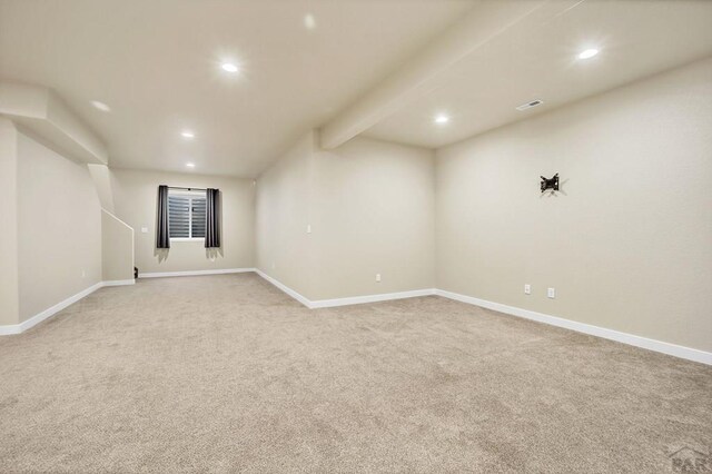 finished basement with baseboards, visible vents, light colored carpet, and recessed lighting