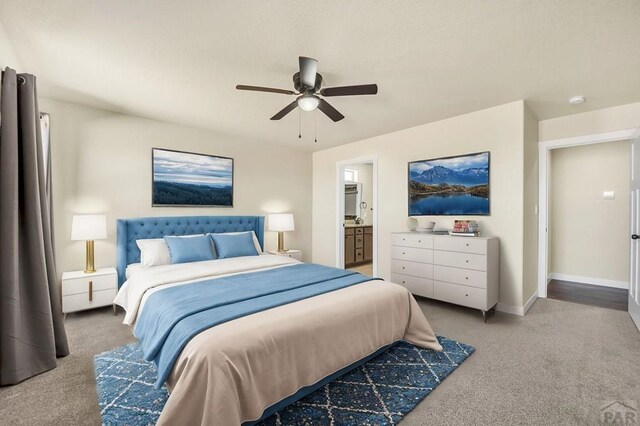 bedroom featuring baseboards, connected bathroom, a ceiling fan, and light colored carpet