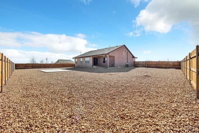 back of house with a patio area, a fenced backyard, and stucco siding