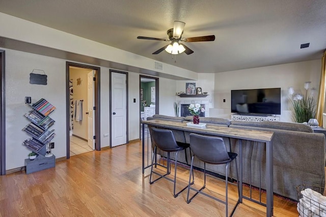 769 S Mccoy Dr, Pueblo West, CO 81007 - kitchen with a kitchen bar, light wood-style floors, a ceiling fan, and visible vents