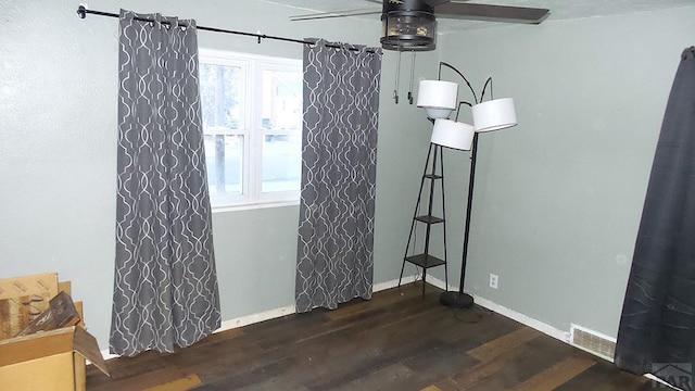 unfurnished dining area featuring ceiling fan, dark wood finished floors, visible vents, and baseboards