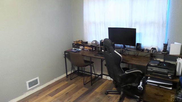 office with dark wood-type flooring, visible vents, and baseboards