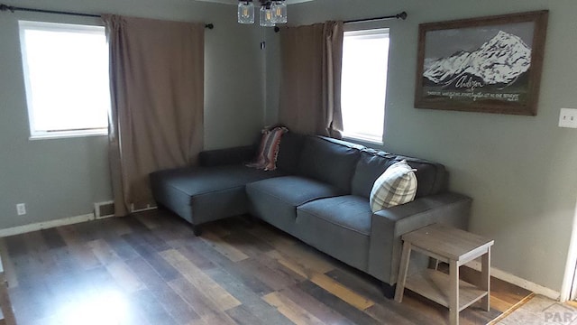 sitting room with plenty of natural light, wood finished floors, visible vents, and baseboards