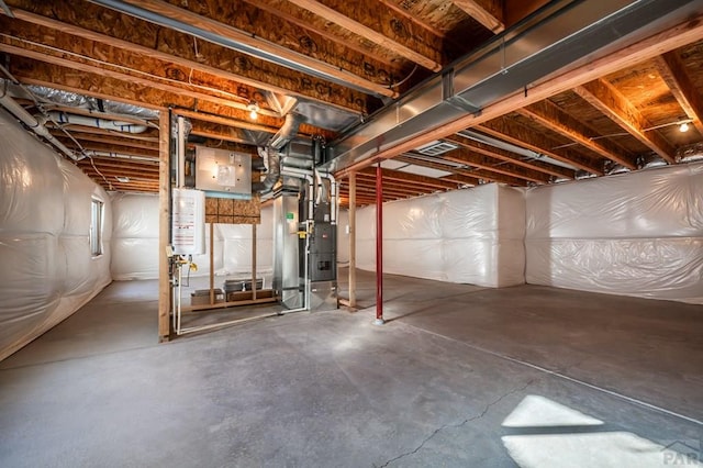 unfinished basement featuring gas water heater and heating unit