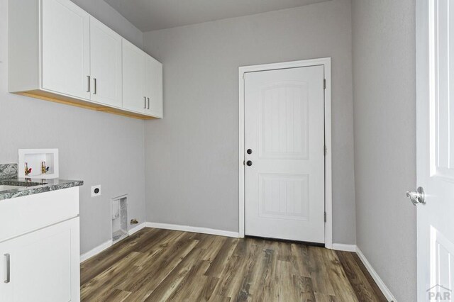 laundry area with cabinet space, baseboards, dark wood finished floors, hookup for a washing machine, and hookup for an electric dryer