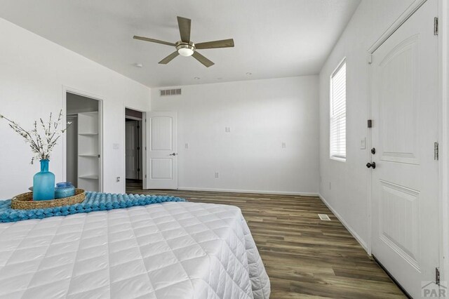 bedroom featuring baseboards, visible vents, dark wood finished floors, and a ceiling fan