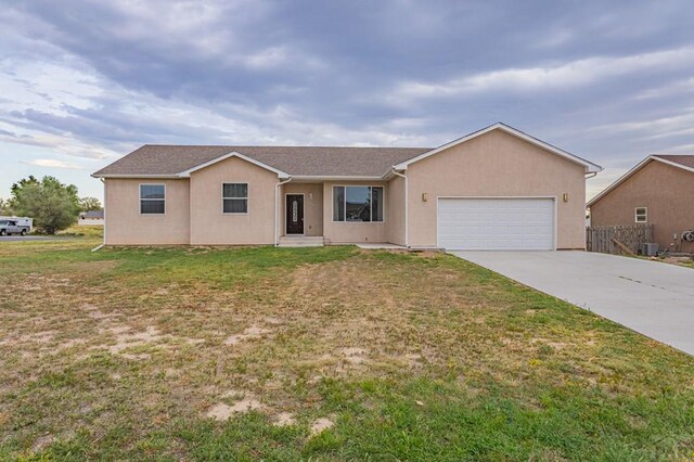 ranch-style house featuring a front yard, central AC unit, an attached garage, and stucco siding