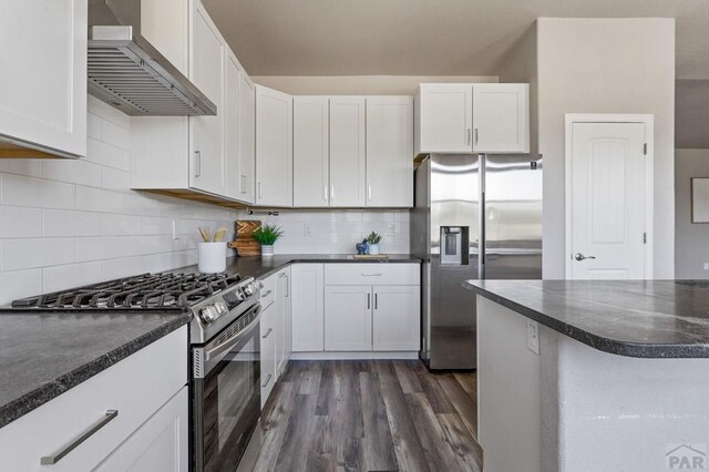 kitchen with wall chimney range hood, appliances with stainless steel finishes, and white cabinets