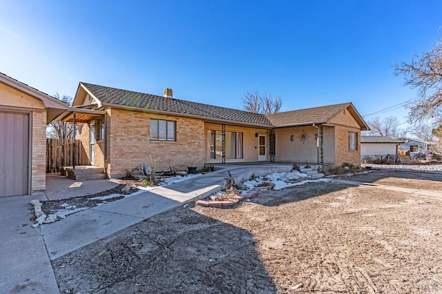 ranch-style house with a chimney and brick siding