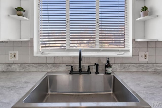 room details with open shelves, backsplash, light countertops, and a sink