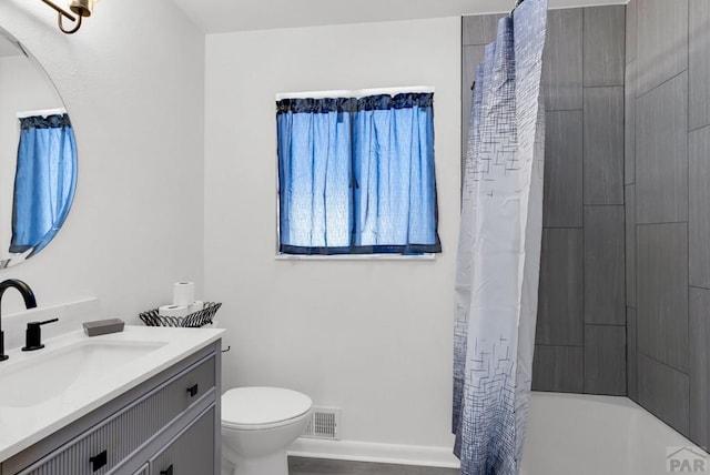 bathroom featuring toilet, vanity, visible vents, and baseboards