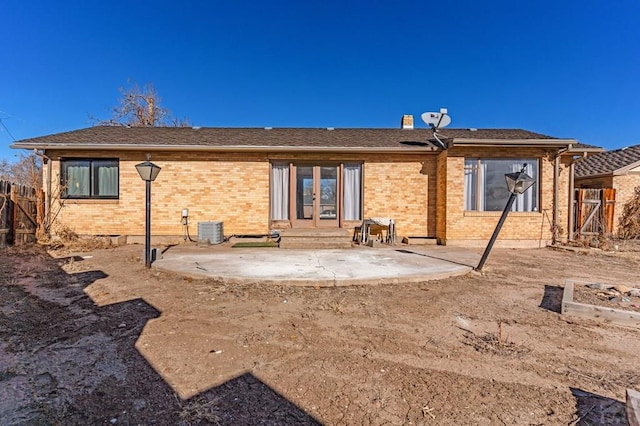 back of property with fence, cooling unit, french doors, a patio area, and brick siding