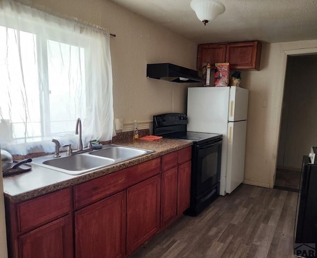 1802 Pine St, Pueblo, CO 81004 - kitchen featuring dark wood finished floors, freestanding refrigerator, a sink, under cabinet range hood, and black electric range oven