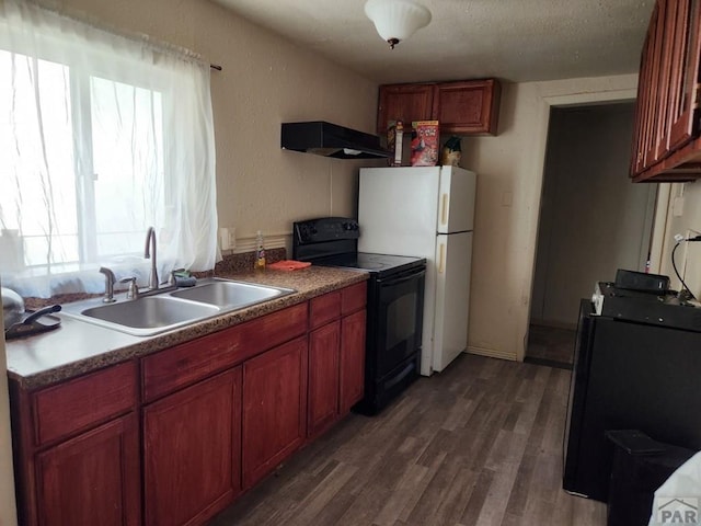1802 Pine St, Pueblo, CO 81004 - kitchen featuring black electric range oven, a sink, under cabinet range hood, dark wood-style floors, and freestanding refrigerator