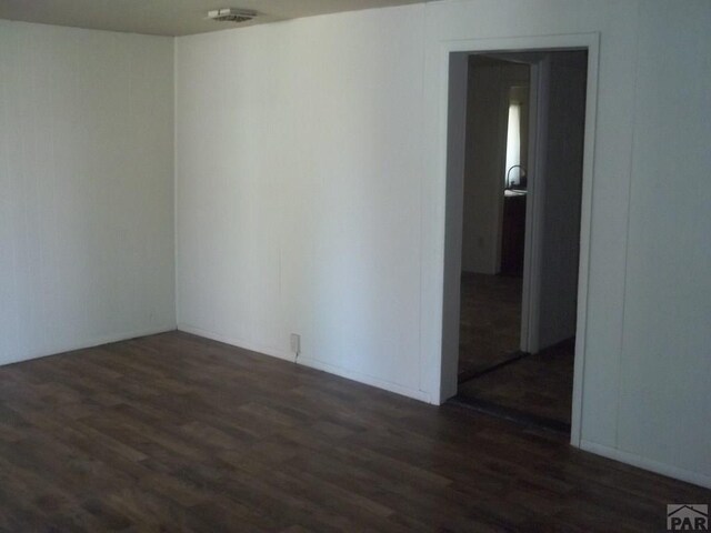 empty room with visible vents and dark wood finished floors