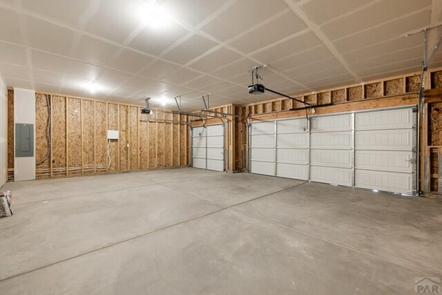 garage with electric panel and a garage door opener