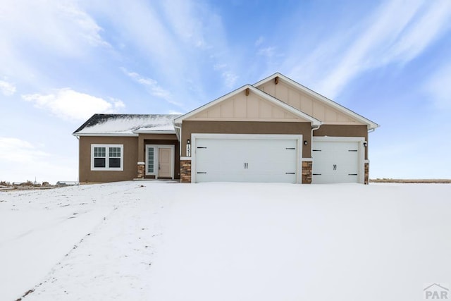 view of front of home featuring board and batten siding, stone siding, and a garage