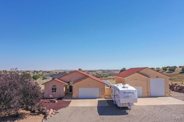 view of front facade featuring a garage, driveway, and stucco siding