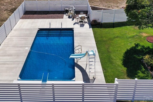 view of swimming pool featuring a fenced in pool, a patio, a fenced backyard, a water slide, and a yard