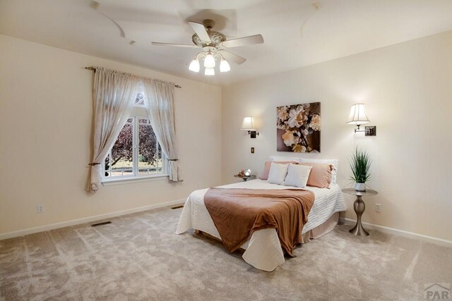 bedroom with visible vents, baseboards, a ceiling fan, and light colored carpet