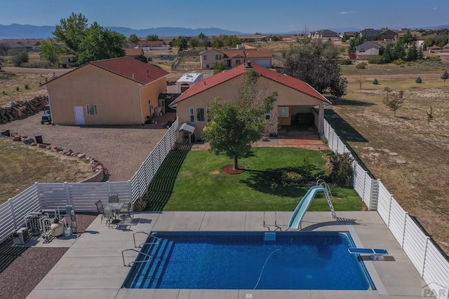 view of pool with a patio, a mountain view, a residential view, a water slide, and a fenced backyard