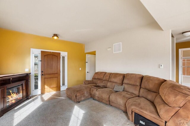 living area with a glass covered fireplace and visible vents