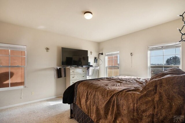 bedroom featuring light colored carpet and baseboards