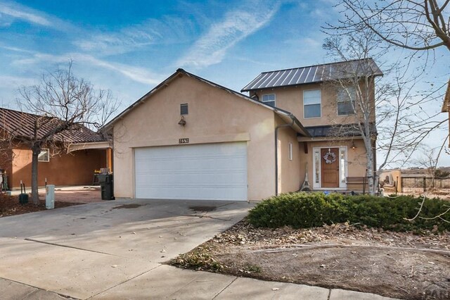 traditional home featuring a garage, driveway, and stucco siding