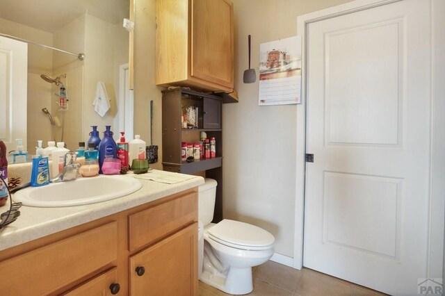 bathroom with toilet, tile patterned flooring, walk in shower, and vanity