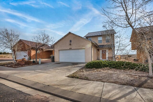 traditional-style home with a garage, concrete driveway, and stucco siding