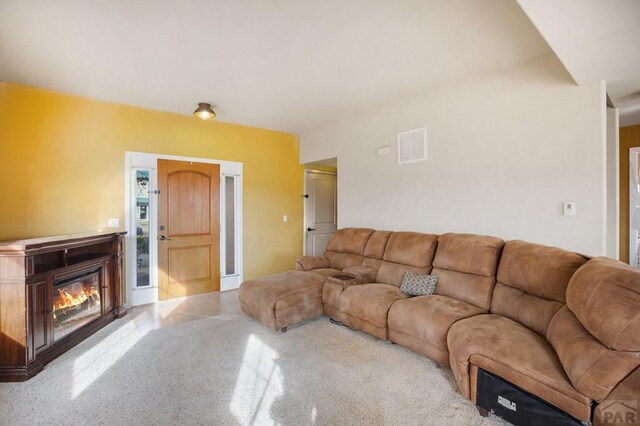 living room with a glass covered fireplace and visible vents