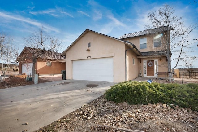 view of front of home with a garage, concrete driveway, and stucco siding