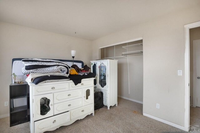 washroom with baseboards and light colored carpet