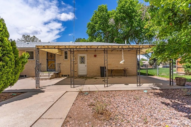 rear view of house featuring fence and brick siding