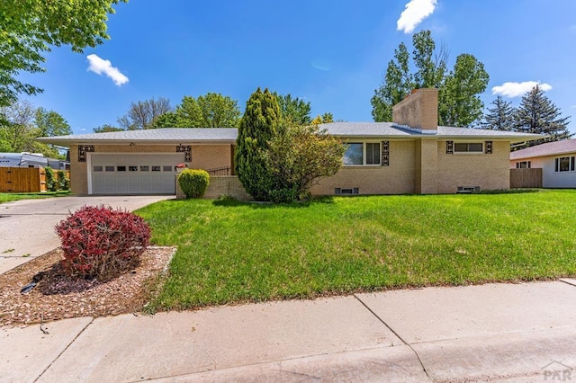 single story home featuring a garage, a front yard, concrete driveway, and a chimney