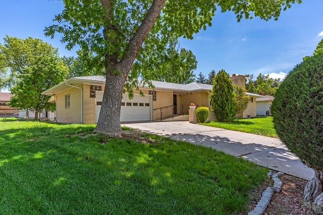 single story home featuring a garage, concrete driveway, a front lawn, and brick siding