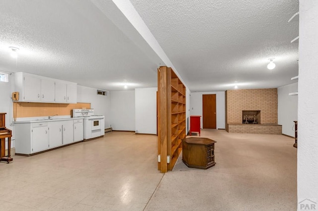 finished basement featuring a brick fireplace, visible vents, and a textured ceiling