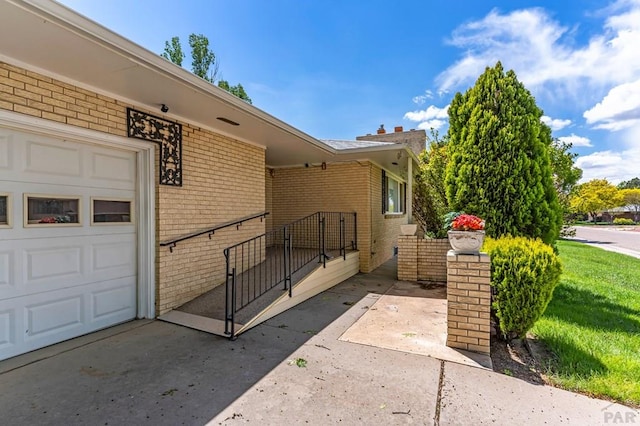 view of exterior entry with brick siding and an attached garage